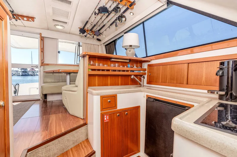 Sunny 1 Yacht Photos Pics Interior of 2001 Riviera 36 Flybridge yacht with kitchen and dining area.