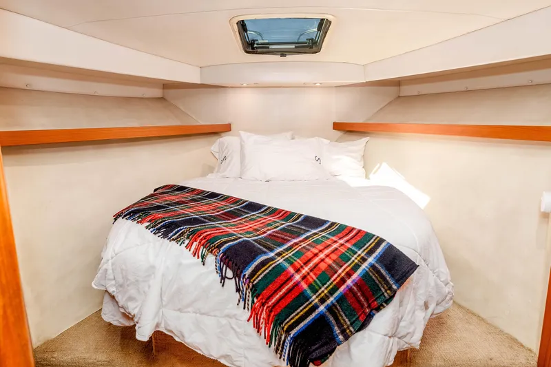 Sunny 1 Yacht Photos Pics Cozy bedroom in 2001 Riviera 36 Flybridge yacht with plaid blanket and skylight.