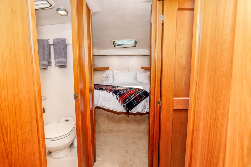 Sunny 1 Yacht Photos Pics Interior of 2001 Riviera 36 Flybridge yacht with cozy bedroom and bathroom.