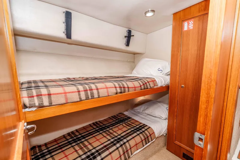 Sunny 1 Yacht Photos Pics Cozy bunk beds in 2001 Riviera 36 Flybridge cabin with plaid blankets.