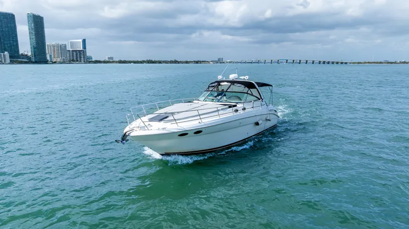 Genesis Yacht Photos Pics 2003 Sea Ray 380 Sundancer cruising on open water with city skyline in background.