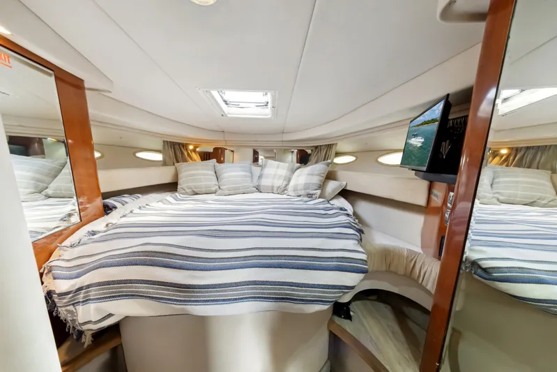 Genesis Yacht Photos Pics Luxurious cabin interior of 2003 Sea Ray 380 Sundancer yacht with cozy bed and striped bedding.