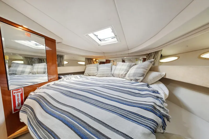 Genesis Yacht Photos Pics Cozy cabin interior of 2003 Sea Ray 380 Sundancer with striped bedding and skylight.