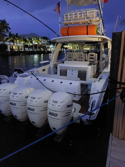 The Reel Deal Yacht Photos Pics 2016 Boston Whaler 420 Outrage boat docked at night with four Mercury 350 engines.