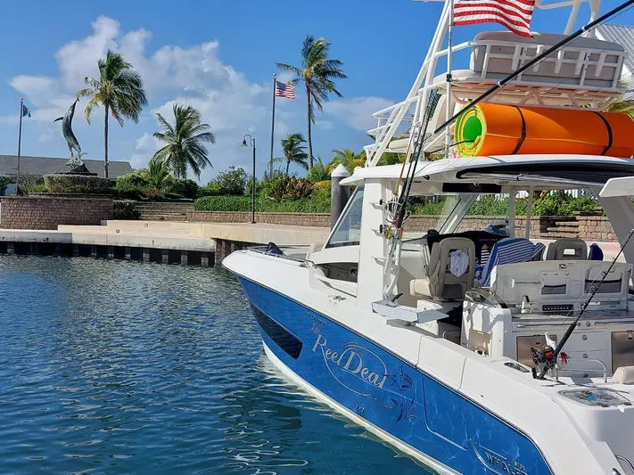 The Reel Deal Yacht Photos Pics 2016 Boston Whaler 420 Outrage docked in a sunny marina with palm trees.