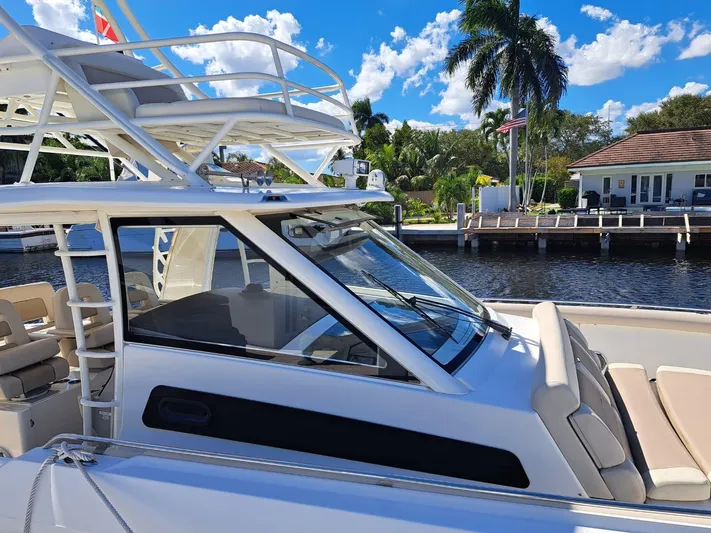 The Reel Deal Yacht Photos Pics 2016 Boston Whaler 420 Outrage boat docked by a waterfront home.
