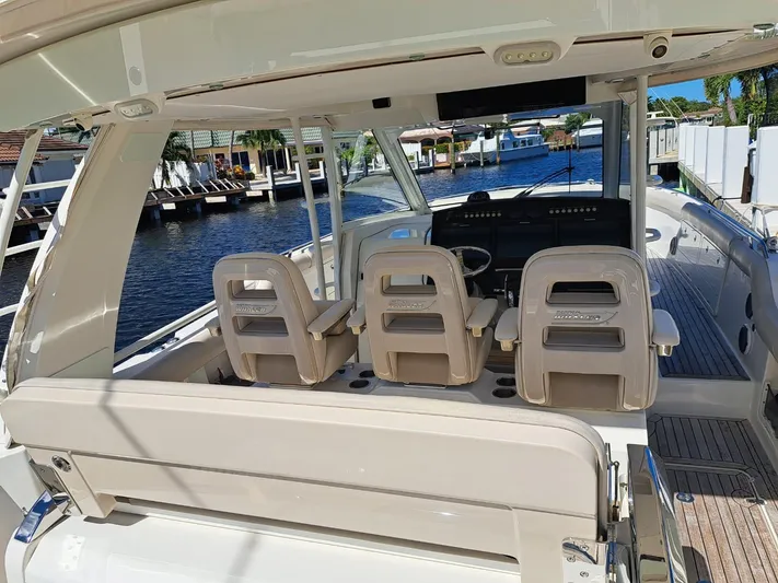 The Reel Deal Yacht Photos Pics 2016 Boston Whaler 420 Outrage boat interior with helm seats and waterfront view.