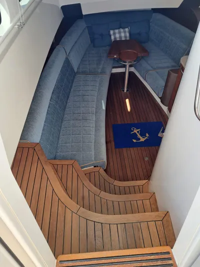 The Reel Deal Yacht Photos Pics Interior of 2016 Boston Whaler 420 Outrage with wooden flooring and blue seating.