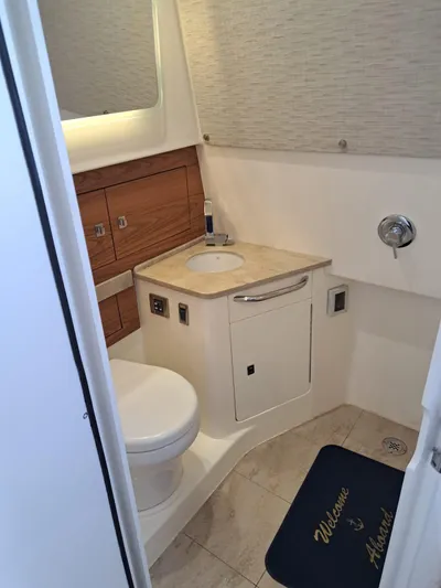 The Reel Deal Yacht Photos Pics 2016 Boston Whaler 420 Outrage bathroom with sink, toilet, and storage cabinets.