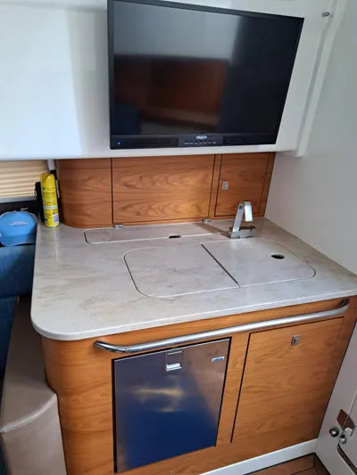 The Reel Deal Yacht Photos Pics 2016 Boston Whaler 420 Outrage interior kitchenette with sink, countertop, and TV.