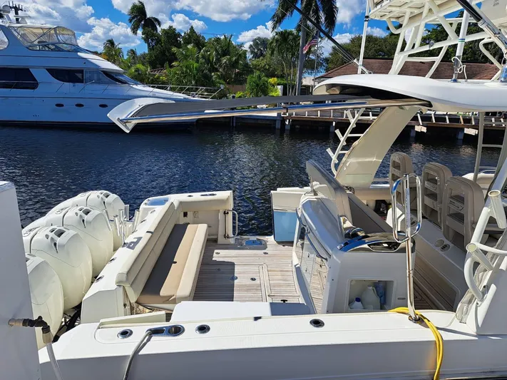 The Reel Deal Yacht Photos Pics 2016 Boston Whaler 420 Outrage docked, showcasing spacious deck and seating area.