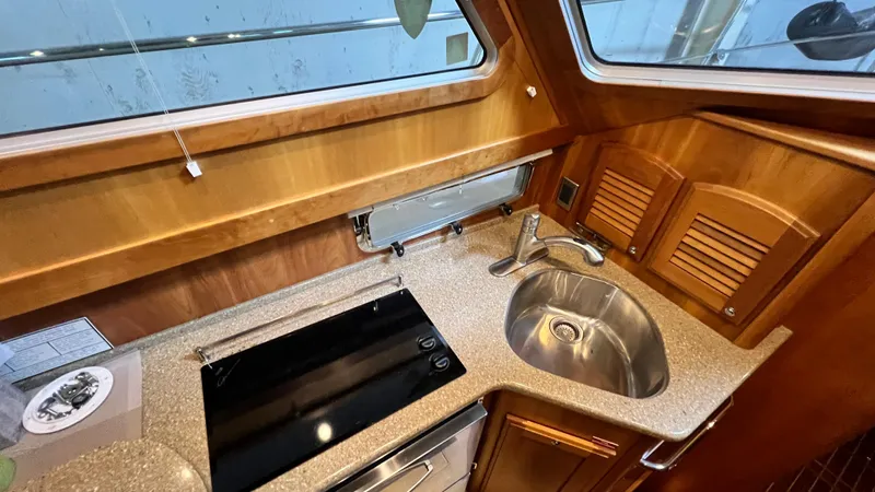 Tempest Yacht Photos Pics 2011 Sabre 40 Sedan yacht kitchen with sink, stove, and wooden cabinetry.
