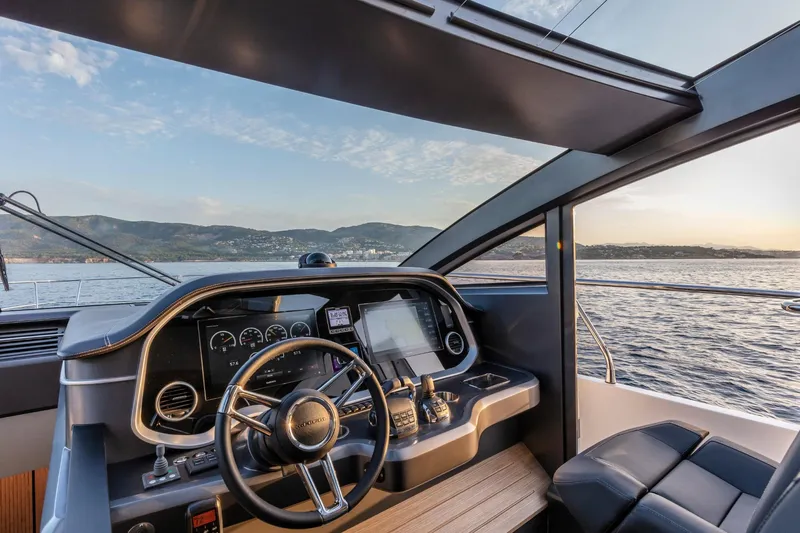 Bahari Yacht Photos Pics Helm of 2020 Pearl 62 yacht with scenic ocean view at sunset.