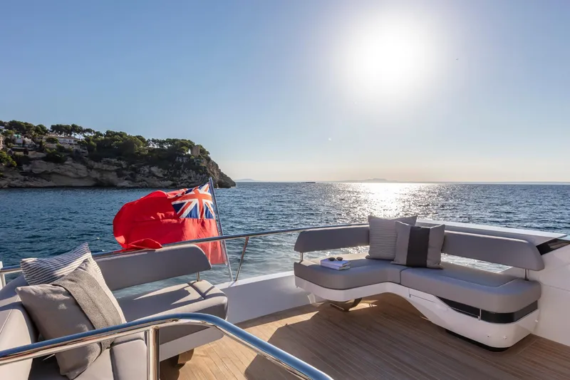 Bahari Yacht Photos Pics Luxurious Pearl 62 yacht deck with ocean view, 2020 model, featuring elegant seating and a flag.