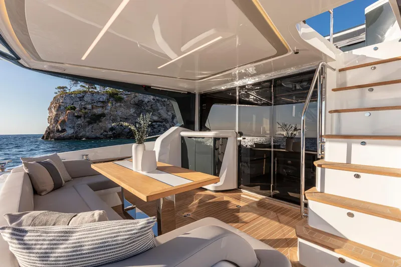 Bahari Yacht Photos Pics Luxurious 2020 Pearl 62 yacht interior with elegant seating, wooden table, and ocean view.