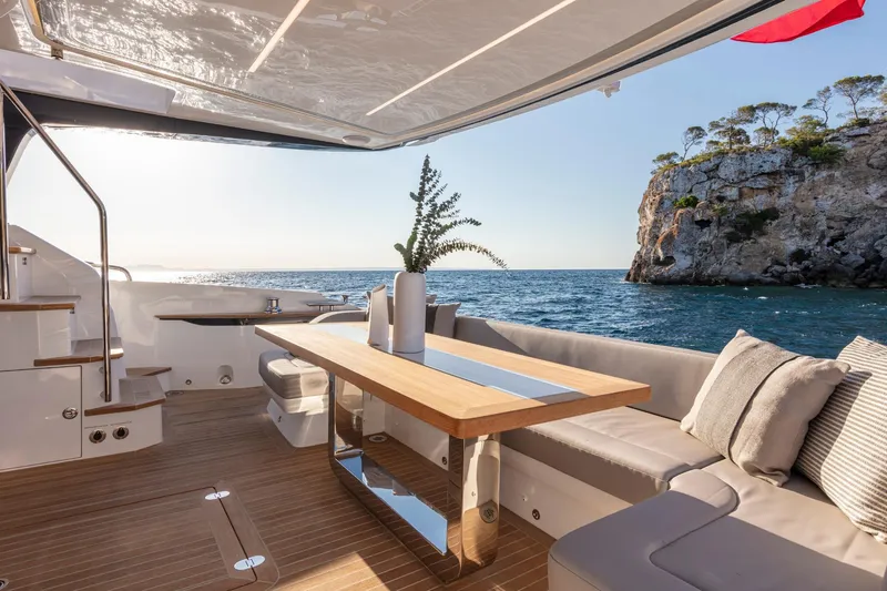 Bahari Yacht Photos Pics Luxurious Pearl 62 yacht deck with ocean view, featuring elegant seating and dining area, 2020 model.