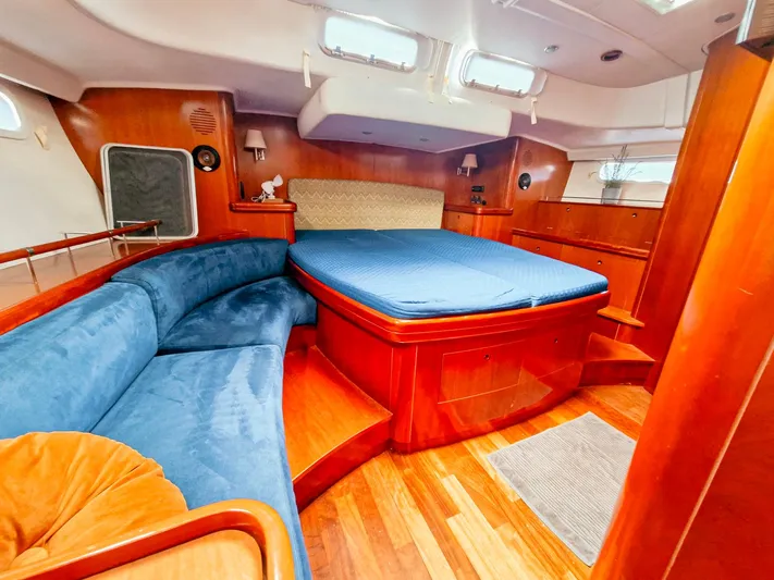  Yacht Photos Pics Luxurious interior of a 2004 Beneteau 57 yacht with wood finish and blue upholstery.