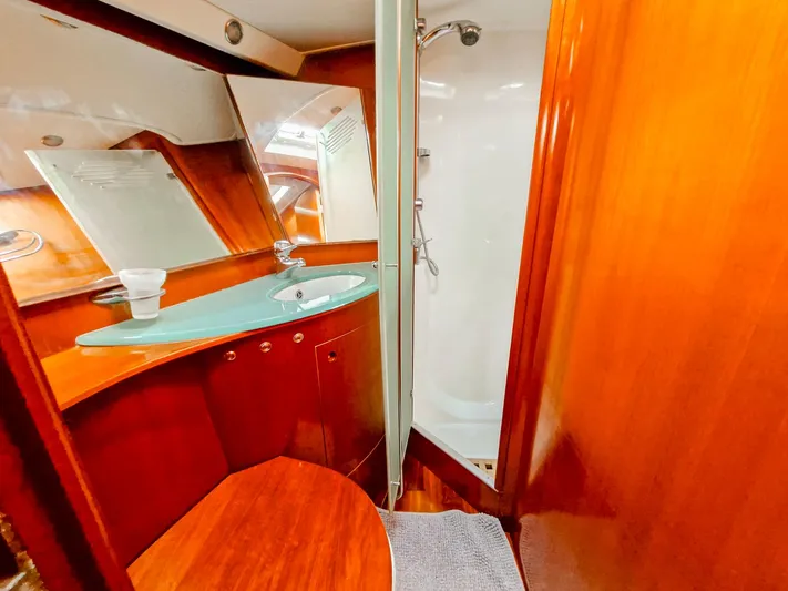  Yacht Photos Pics Luxurious bathroom in 2004 Beneteau 57 yacht with wooden cabinetry and modern fixtures.