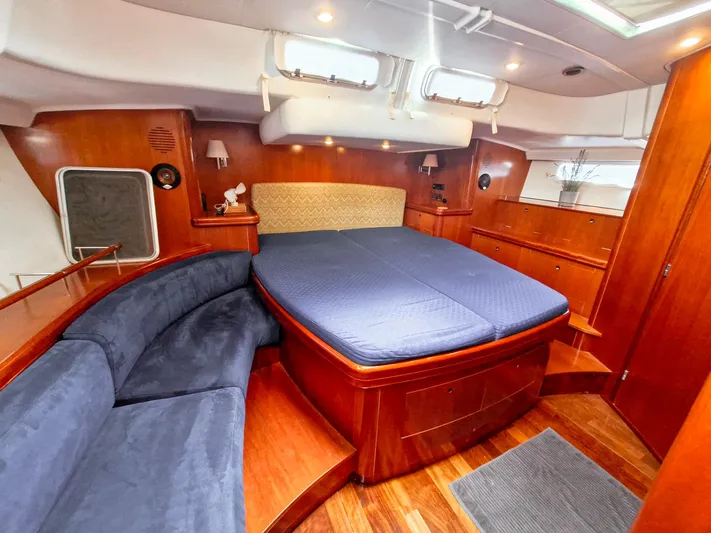  Yacht Photos Pics Luxurious 2004 Beneteau 57 yacht cabin with wood finish, double bed, and blue seating.