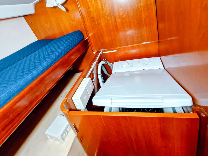  Yacht Photos Pics Laundry area in 2004 Beneteau 57 yacht with wooden cabinetry and compact washing machine.