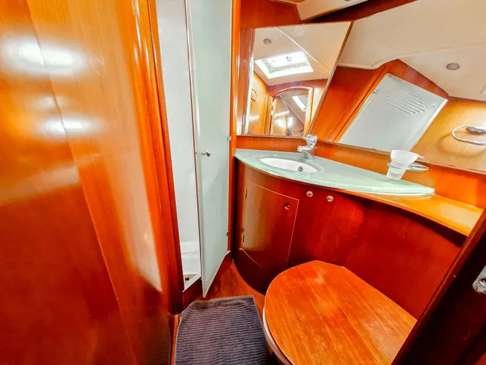  Yacht Photos Pics Luxurious 2004 Beneteau 57 yacht bathroom with wooden cabinetry and modern fixtures.