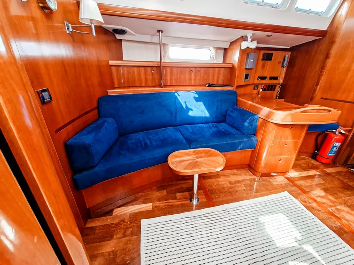  Yacht Photos Pics Interior of 2004 Beneteau 57 yacht with blue sofa and wooden furnishings.