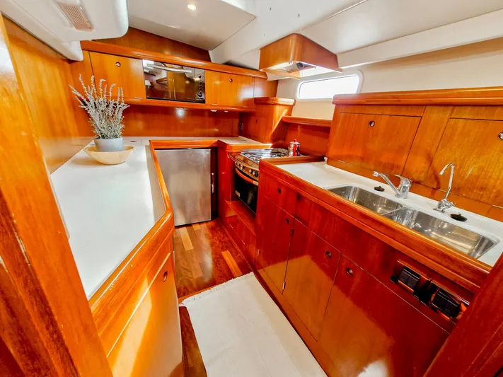  Yacht Photos Pics Luxurious wooden interior of a 2004 Beneteau 57 yacht kitchen with modern amenities.