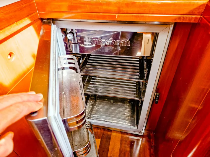 Yacht Photos Pics Open fridge in 2004 Beneteau 57 yacht interior, showcasing stainless steel shelves.