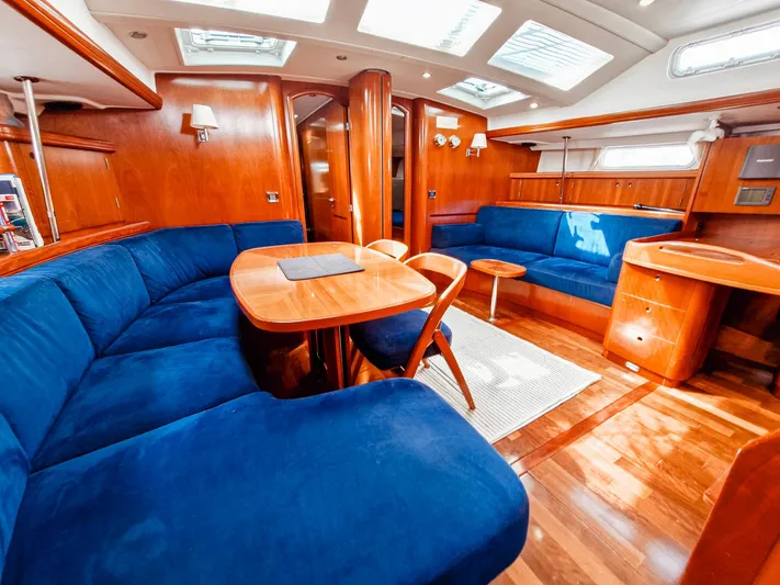  Yacht Photos Pics Luxurious interior of 2004 Beneteau 57 yacht with blue seating and wooden finishes.