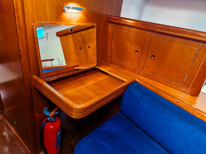  Yacht Photos Pics Luxurious wooden interior of 2004 Beneteau 57 yacht with blue seating and vanity mirror.
