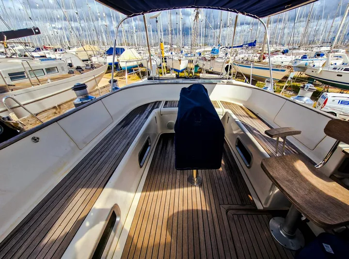  Yacht Photos Pics 2004 Beneteau 57 yacht cockpit with wooden deck, marina view, and covered helm.