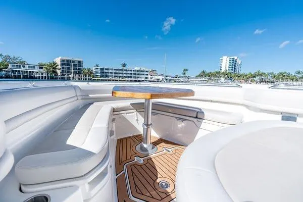 Yacht Photos Pics 2018 Boston Whaler 350 Outrage boat interior with seating and table, under clear blue sky.