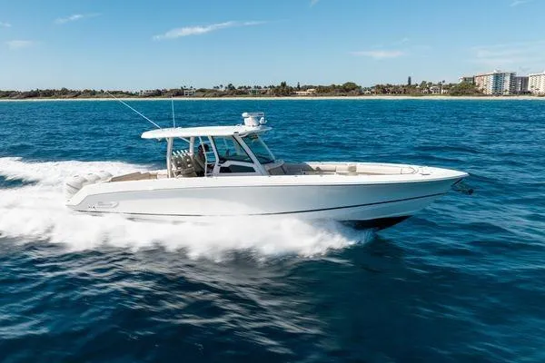  Yacht Photos Pics 2018 Boston Whaler 350 Outrage cruising on open water near coastline.