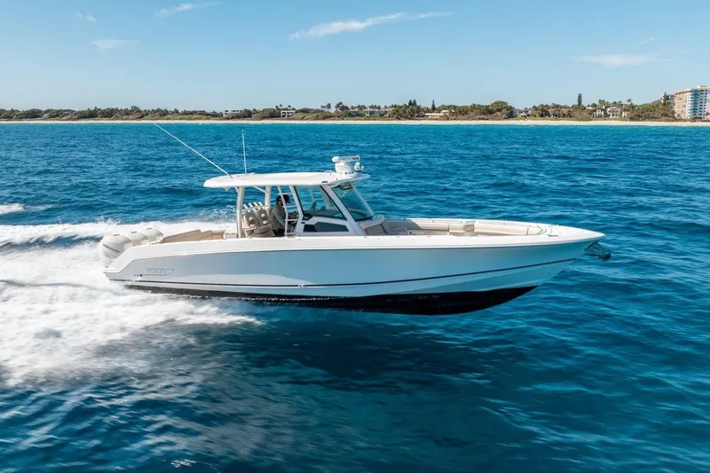  Yacht Photos Pics 2018 Boston Whaler 350 Outrage cruising on blue ocean near coastline.