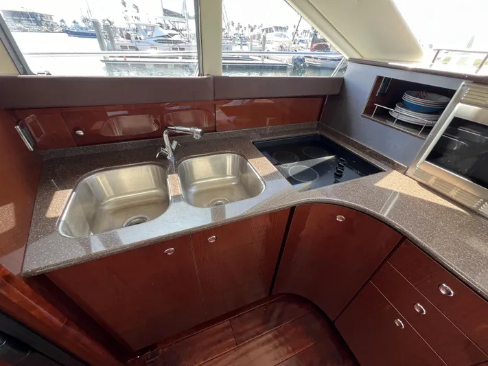  Yacht Photos Pics Luxurious kitchen in a 2013 Meridian 441 Sedan yacht with dual sinks and modern appliances.