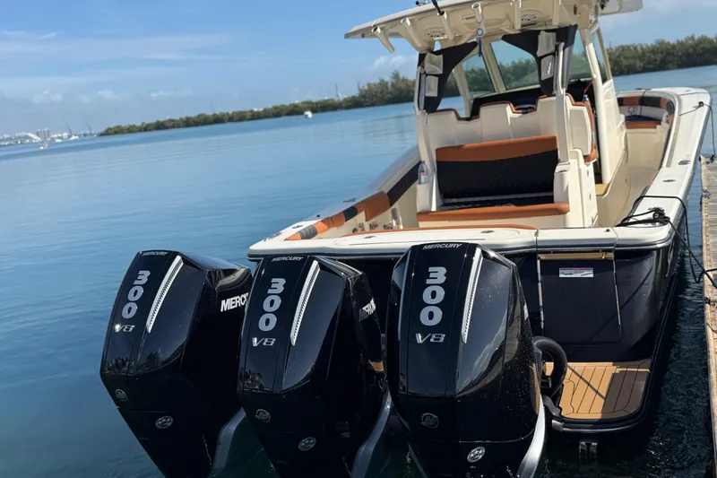  Yacht Photos Pics 2019 Scout 355 LXF boat with triple Mercury 300 V8 engines docked by the water.