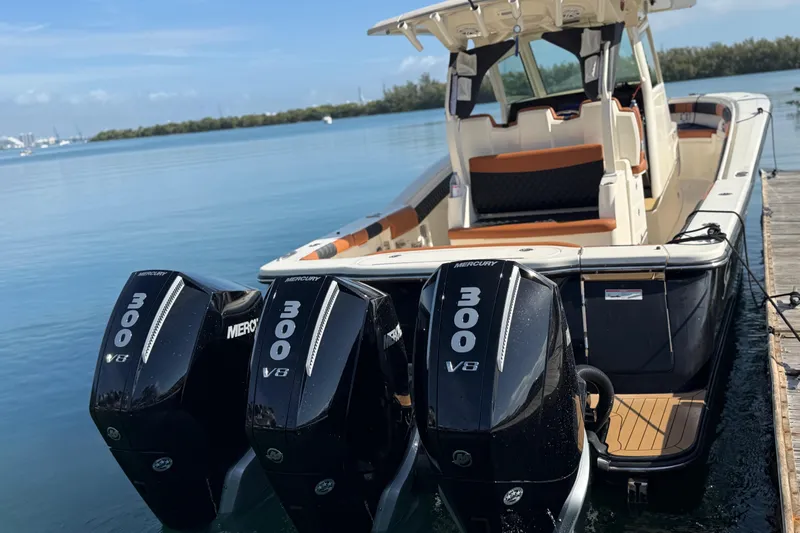  Yacht Photos Pics 2019 Scout 355 LXF boat with triple Mercury 300 V8 engines docked by the water.