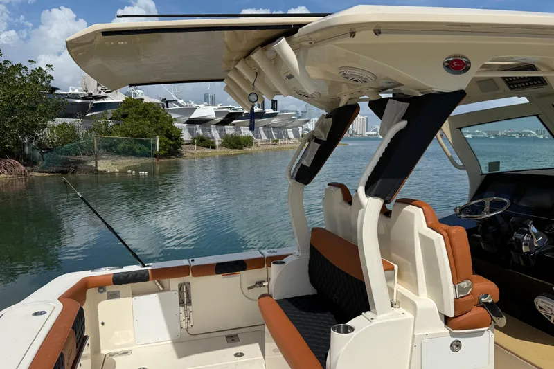 Yacht Photos Pics 2019 Scout 355 LXF boat interior with seating and fishing rod, docked near yachts.