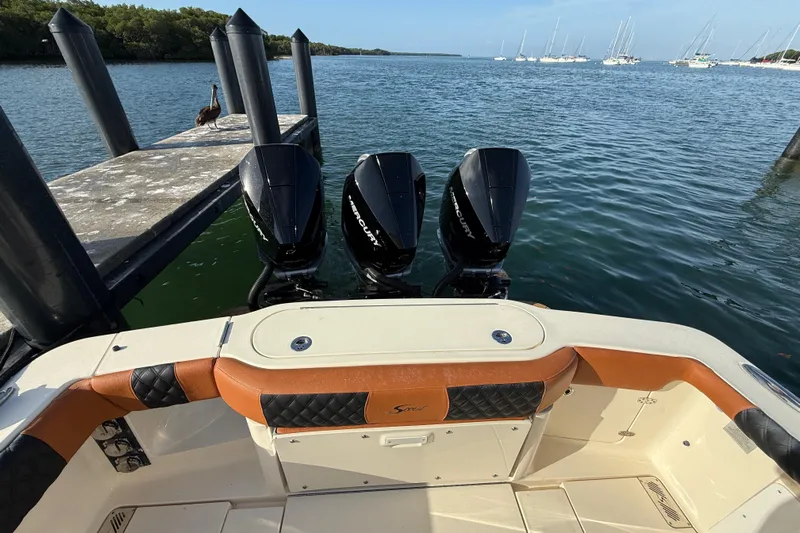  Yacht Photos Pics 2019 Scout 355 LXF boat with triple Mercury engines docked by the water.