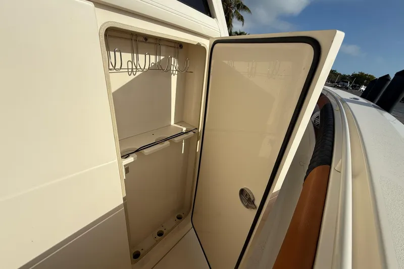  Yacht Photos Pics 2019 Scout 355 LXF boat storage compartment with open door, showcasing interior hooks.