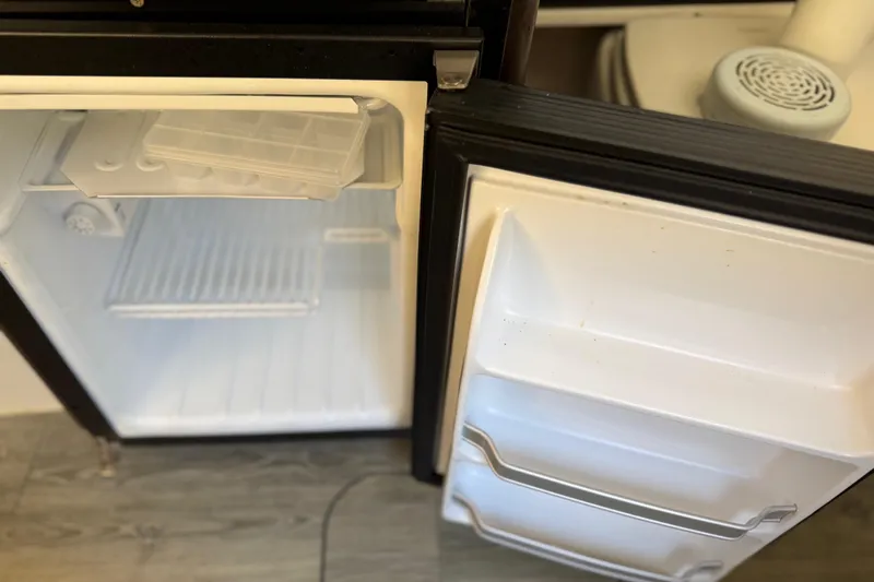  Yacht Photos Pics Open refrigerator door on a 2019 Scout 355 LXF boat, showing empty interior shelves.