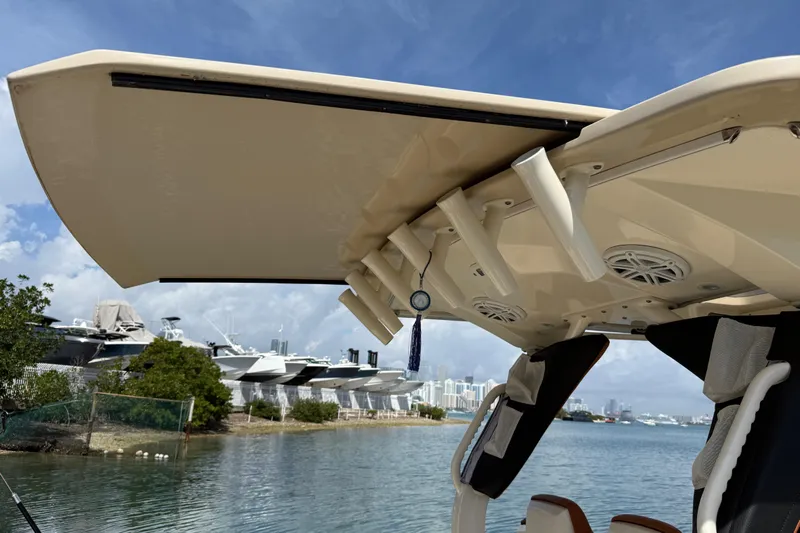  Yacht Photos Pics 2019 Scout 355 LXF boat with rod holders and speakers, docked near a marina.