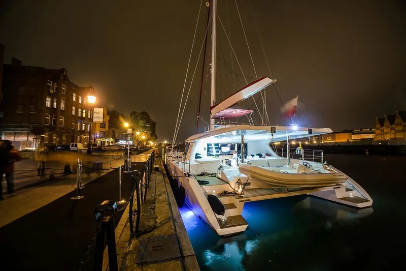 Darlin ( Ex Fine Line) Yacht Photos Pics Luxurious 2015 Sunreef 60 LOFT catamaran docked at night, illuminated by soft lights.