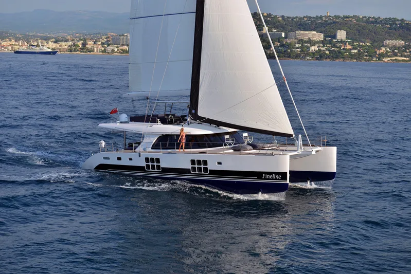 Darlin ( Ex Fine Line) Yacht Photos Pics Sunreef 60 LOFT 2015 sailing catamaran on open sea with coastal background.