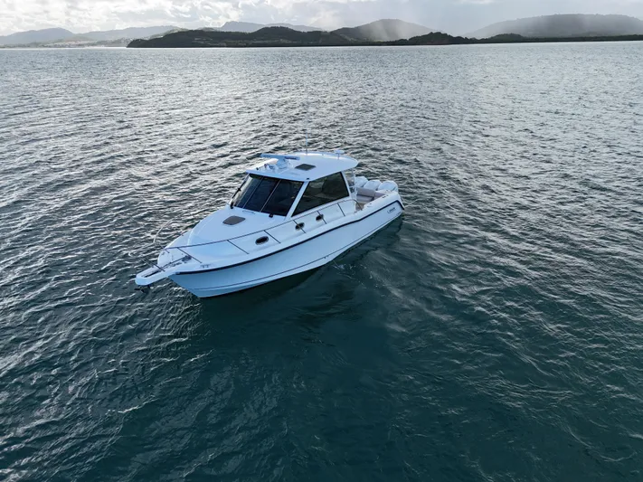 Del Mar Yacht Photos Pics 2015 Boston Whaler 345 Conquest boat on calm water with scenic background.