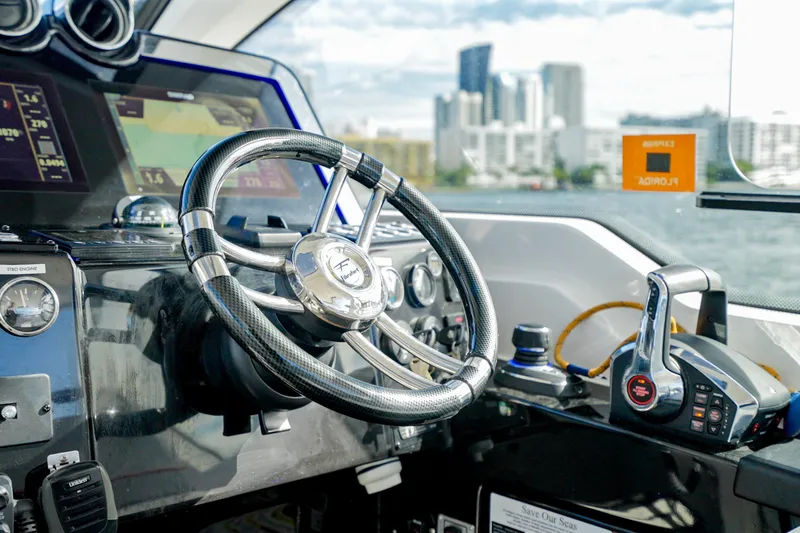  Yacht Photos Pics Steering wheel and controls of 2026 Granfort 37 boat, city skyline in background.