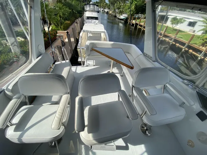 The Jolly Rogers Yacht Photos Pics 1987 Hi-Star Sportfish boat interior with white seating and table on a sunny day.