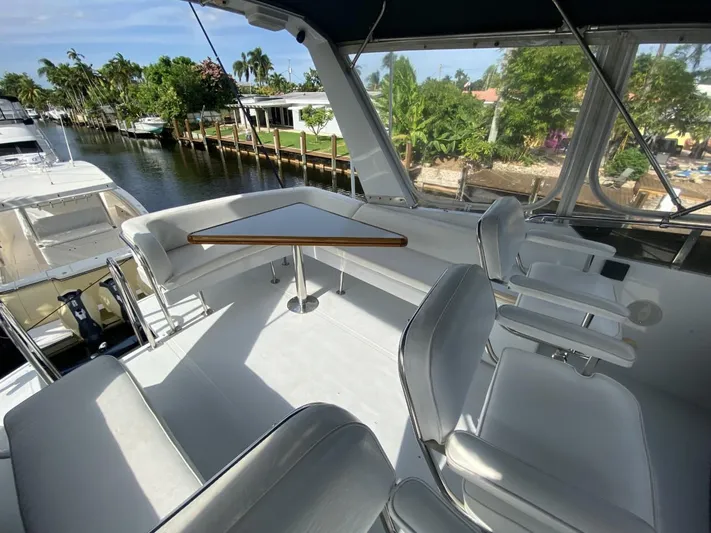 The Jolly Rogers Yacht Photos Pics 1987 Hi-Star Sportfish boat with spacious seating and table on deck.
