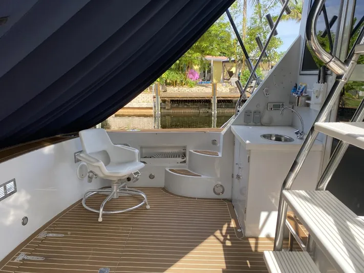 The Jolly Rogers Yacht Photos Pics 1987 Hi-Star Sportfish boat deck with seating and sink, docked by the water.