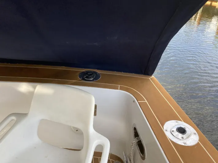 The Jolly Rogers Yacht Photos Pics 1987 Hi-Star Sportfish boat interior with white seat and wooden trim.